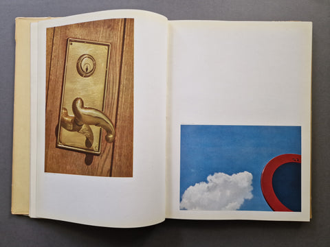 An open book spread showing two colour image. One of a door knob on the left page, and one of a traffic sign and a blue sky with a white cloud at the bottom of the right page.