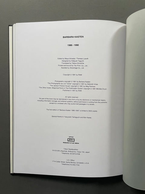An open book showing the interior title page for 'Barbara Kasten 1986-1990,' photographed against a dark gray background.