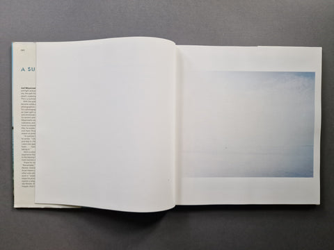An open book, showing a seascape on the right.