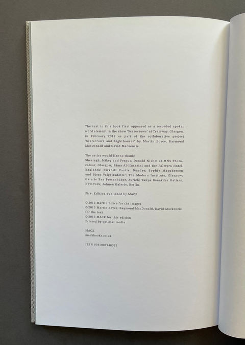 An open book showing the printed title and copyright page on both pages, photographed against a dark gray background.