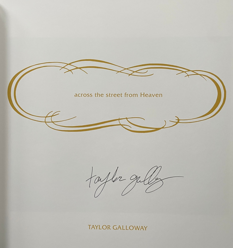 A close-up of a white printed book page featuring a gold decorative frame, the text 'across the street from Heaven,' Taylor Galloway's signature, and 'TAYLOR GALLOWAY' printed below in gold, set against a dark gray background.