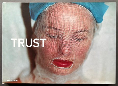 Book titled 'Trust' by Adam Broomberg and Oliver Chanarin with a cover featuring a woman's face covered in gauze.