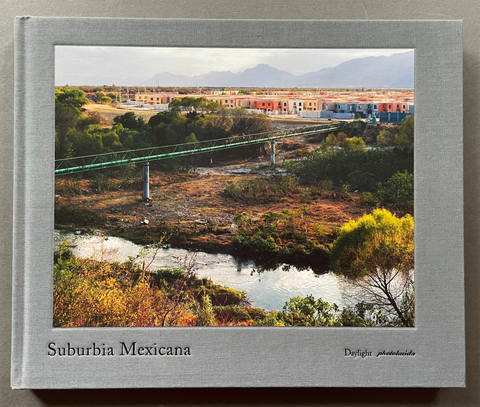 Book cover of Suburbia Mexicana by Alejandro Cartagena with a color photo of a landscape.