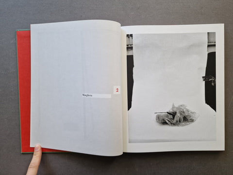 An open book showing a black-and-white photograph on the right page and a blank interior spread on the left.