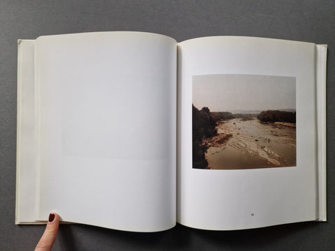 An open book showing a blank left page and a landscape photograph on the right page