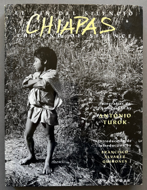 Book titled 'Chiapas: El Fin Del Silencio/The End of Silence' by Antonio Turok with a cover featuring the black and white image of a young Mexican boy with his arms crossed and surrounded by fauna.