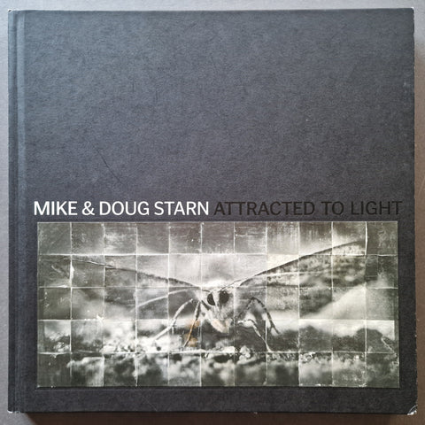 The book cover of 'Attracted to Light' by Mike & Doug Starn, featuring a dark gray textured cover with a central black-and-white collage of a moth.