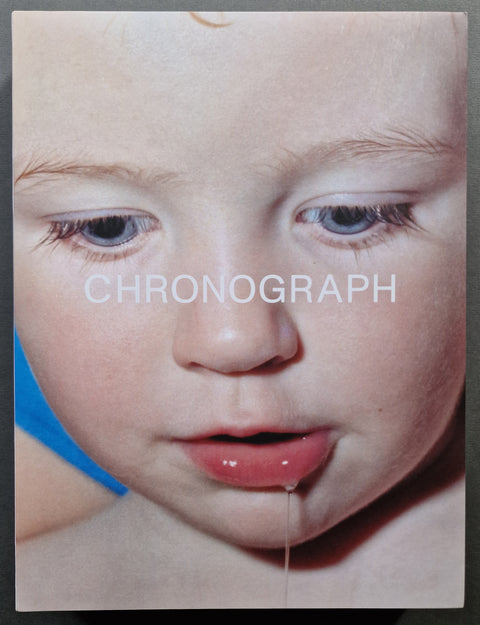 A book cover featuring a close-up photograph of a child's face with the word 'CHRONOGRAPH' overlaid in white text. A small strand of saliva is visible hanging from the lower lip of the child.