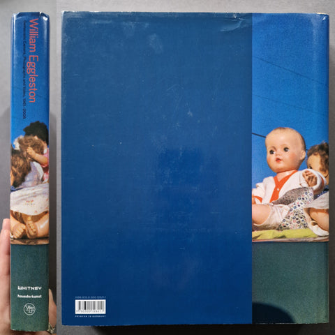 The spine and back cover of Democratic Camera Photographs and Video 1961-2008 by William Eggleston in blue