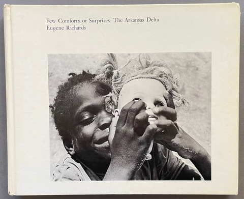 A hardcover book titled 'Few Comforts or Surprises: The Arkansas Delta' by Eugene Richards, featuring a black and white photograph of a child on the cover, set against a solid gray background.