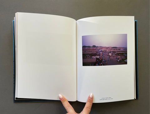 An open hardcover book or photo journal laid flat on a dark gray surface, with blank white pages on the left and a printed photograph on the right.