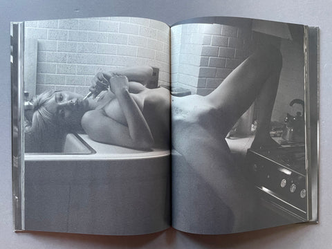 Open book showing a black and white photograph of a person in a kitchen.