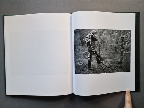 An open book, showing a black-and-white photograph printed on the right page of an otherwise blank white left page.