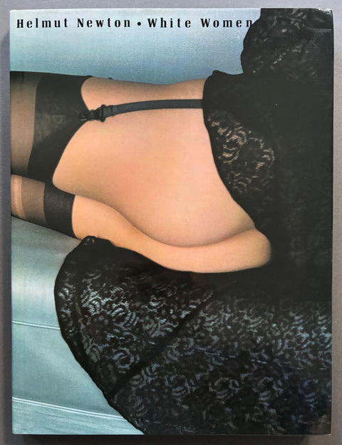 Book titled 'White Women' by Helmut Newton with a cover featuring aspects of a naked woman's body.
