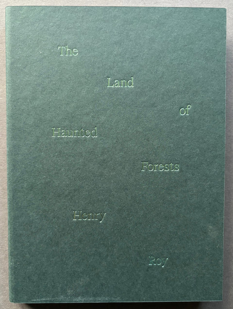 Book titled 'The Land of Haunted Forests' with a green cover with embossed type.