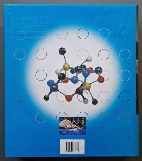 A blue book featuring a large central molecular model graphic, a grid of colored circles, small text blocks, and a barcode label near the bottom.