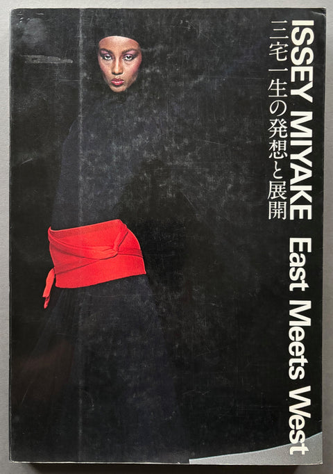 book titled 'East Meets West' by Issey Miyake with a black cover featuring a model wearing the artists creation.