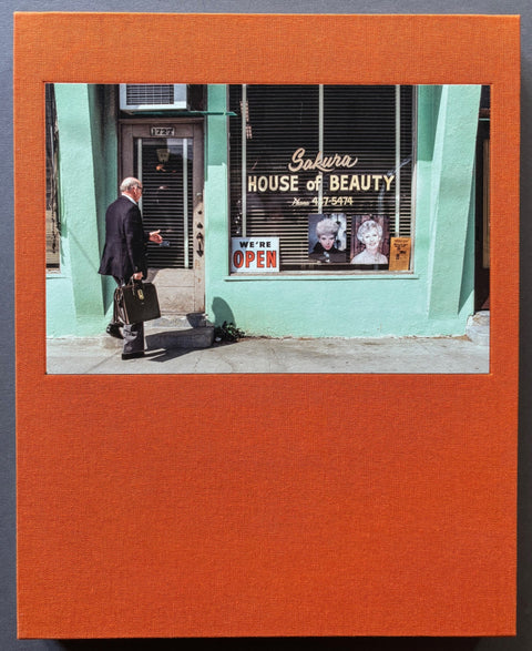 Book titled ' Too Many Products Too Much Pressure' by Janet Delany with an orange cover featuring the photograph of a sales man entering a beauty salon.