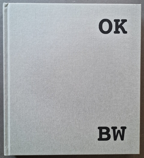A square light gray textured book cover with the black letters 'OK' at the top right and 'BW' at the bottom right by Jason Lee.