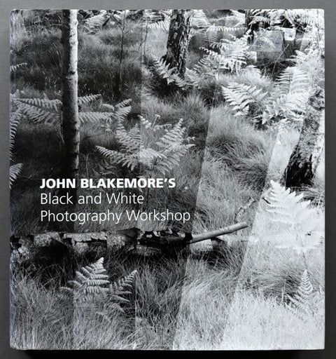 Book titled 'John Blakemore's Black and White Photography Workshop' by John Blakemore with a black and white featuring featuring an image of grass, ferns and tree trunks.