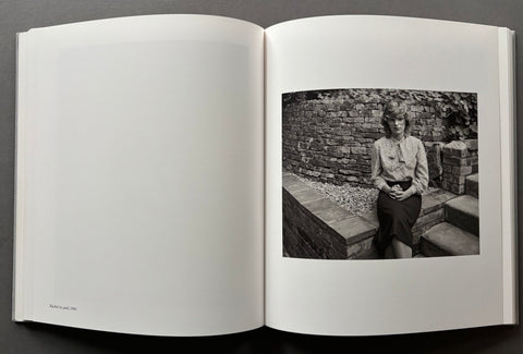 An open book spread on a dark gray background, showing a black-and-white photograph printed on the right page of an otherwise blank white page.
