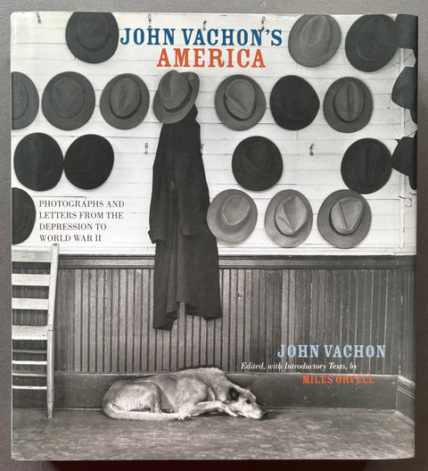 Book titled 'John Vachon's America' with a cover featuring an image of a wall covered in hats and a dog lying on the floor.