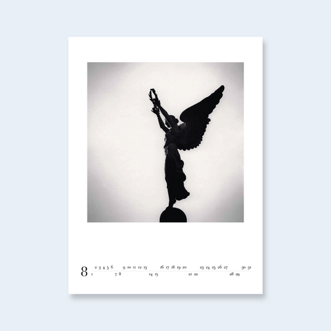 A minimalist calendar page of an angel statue holding a lyre.