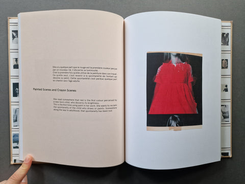 An open book showing printed text on the left page and a large inset photograph of a person wearing a dress, the dress is painted in red
