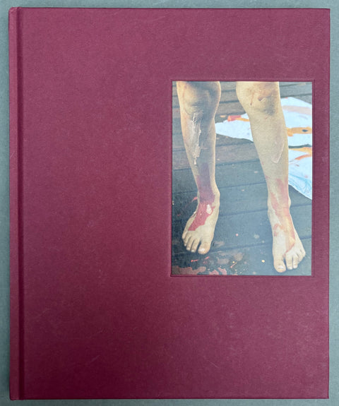 Book titled 'In Passing' by Lisa Sorgini with a red cover featuring an image of a pair of legs.