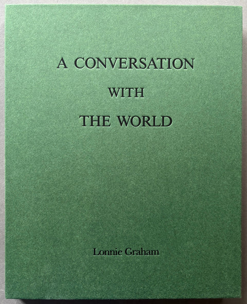 Book titled 'A Conversation With The World' by Lonnie Graham with a green cover.