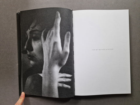 Spread of the book showing another black and white portrait of a woman holding her hand in front of her face, covering half of it.