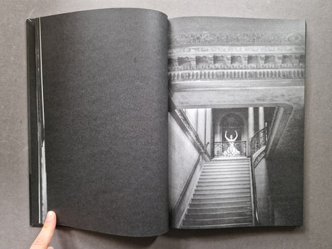 Spread of a book showing a black and white portrait of a woman who appears to be dancing on top of some stairs