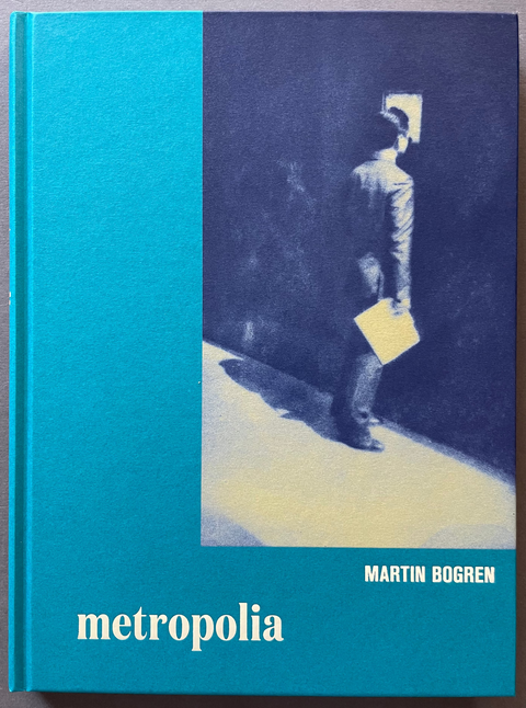 Front cover of Metropolia by Martin Bogren with an image of a man looking through a window.