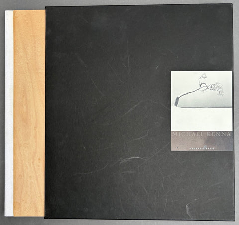 Book titled 'Hokkaido' by Michael Kenna with a black slipcase including an image of a tree in snow and wooden boards.