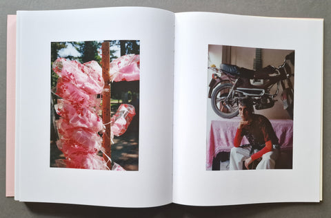 An open book, showing two printed photographs on the pages: one of pink hanging cotton candy on the left, and one of a seated person with a motorcycle in the background on the right.