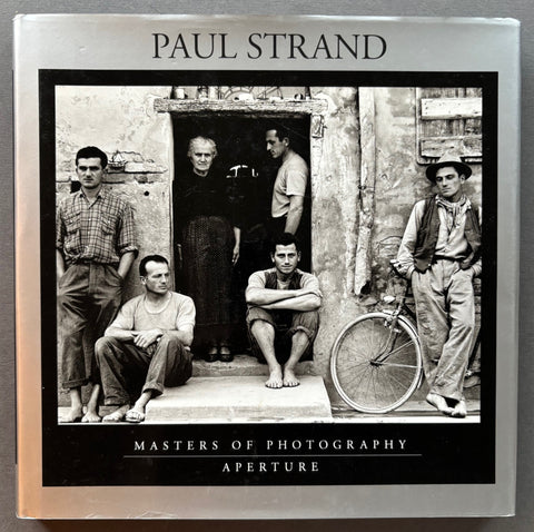 Book titled 'Paul Strand' by Paul Strand with a cover featuring the image of several people standing around a doorway.