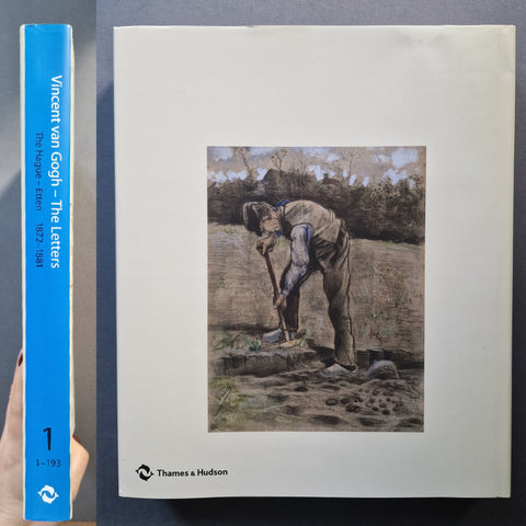 A hardcover book of Vincent van Gogh's letters, Volume 1, held by a hand on the left, with the blue spine visible next to the off-white front cover showing a painting of Van Gogh at work. Published by Thames & Hudson.