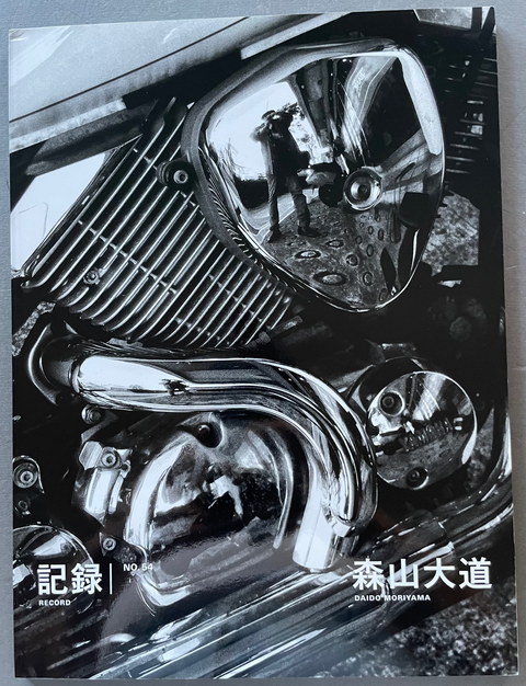Front cover of Record No.54 by Daido Moriyama with a black and white image of a motorbike and Daido's reflection in it.
