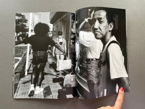 Open book showing black and white photos of people on a street.