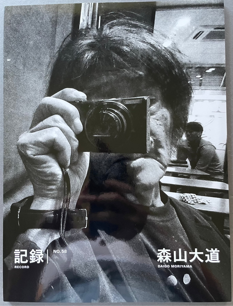 Front cover of Record No.58 by Daido Moriyama with a black and white image of Daido holding a camera.