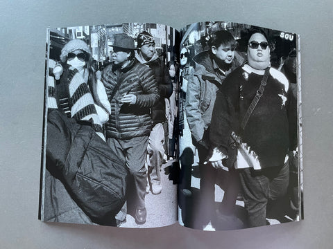 Open book showing black and white photographs of people on a street.