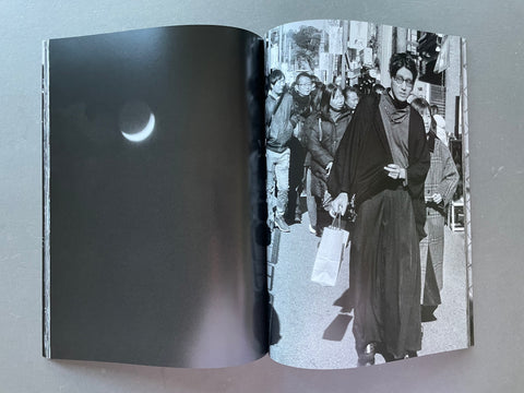 Open book showing black and white photographs of people on a street.