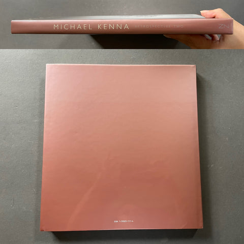 Michael Kenna Photography Book with a dusty rose pink cover, shown from both the spine and the front cover against a dark gray background.