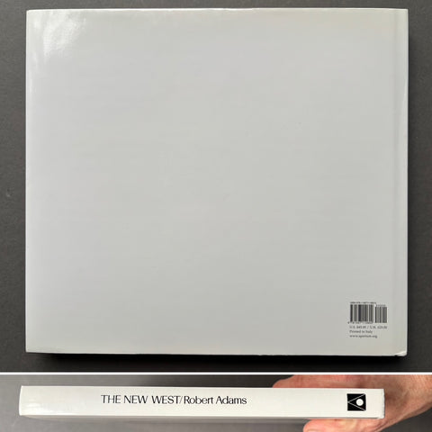 Book titled 'The New West' by Robert Adams on a dark surface