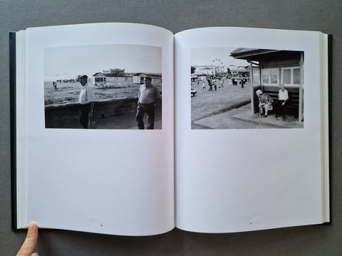 An open book, showing two black-and-white printed photographs on the left and right pages.