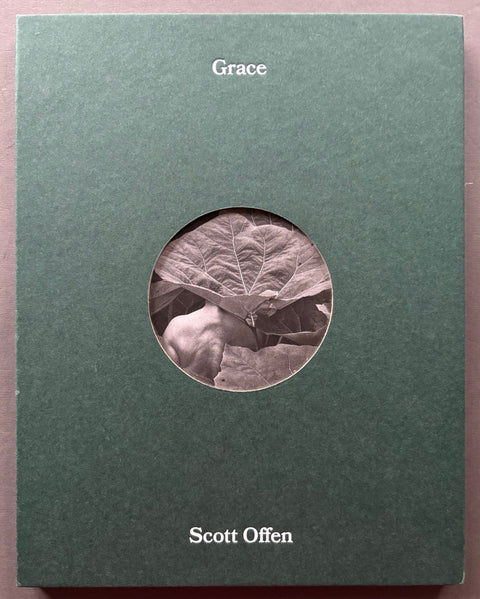 Book titled 'Grace' by Scott Offen with a green cover and a circular cut out revealing a section of a black and white image underneath.