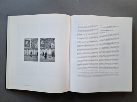An open book, showing two printed pages with black text and two small black-and-white street scene photographs on the left page.