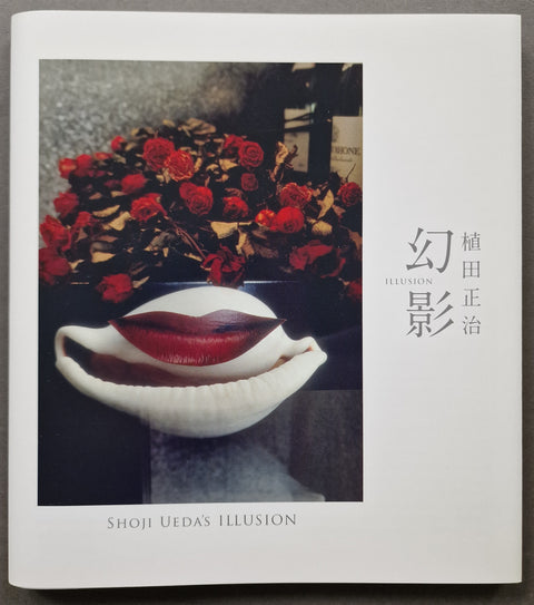 A Japanese art book titled 'Shoji Uedas Illusion' by Toshihiro Ueda, featuring a cover photograph of red roses and a white shell with red lips inside, photographed flat on a gray surface.