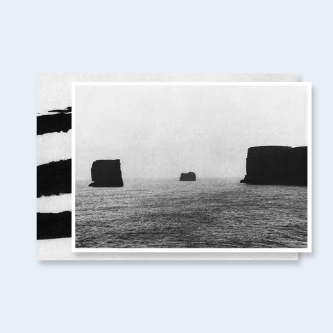The deluxe edition of Unseen by Jungjin Lee featuring the cover in gray and black and the limited edition signed print of a seascape with rocks in black and white