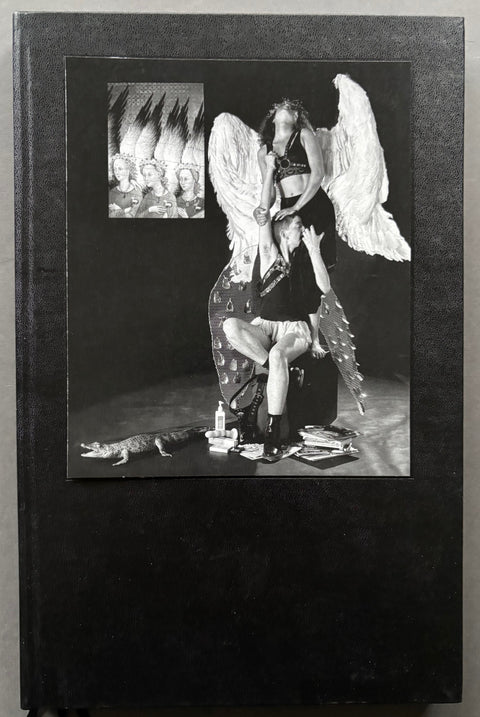 Book titled 'Tessa Boffin' edited by Sunil Gupta with a black cover featuring a tipped in image of a woman wearing large white wings standing on a chair behind another woman who is sitting on the same chair.
